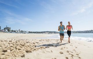 una pareja corriendo por la playa en su retiro para adelgazar en España