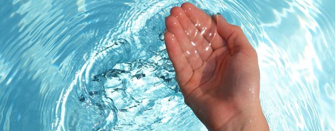 manos dentro del agua termal 