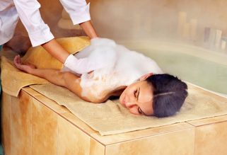 mujer cubierta de burbujas durante un lavado de hidroterapia