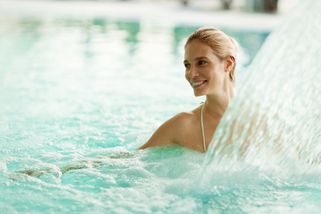 una mujer disfruta del agua de la piscina en una terma de Alemania