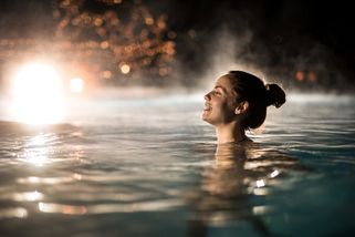 una mujer bañándose en una terma de Hungría por la noche